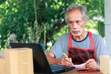 A healthy retired old man is checking and taking orders. Owner of a private business.
