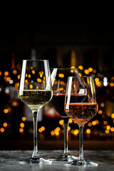 Wine glasses set. Red, white, rose wines on dark background with bottles. Wine bar, shop, tasting