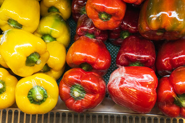 Red and yellow peppers wrapped in clean and neat plastic sold in supermarkets.