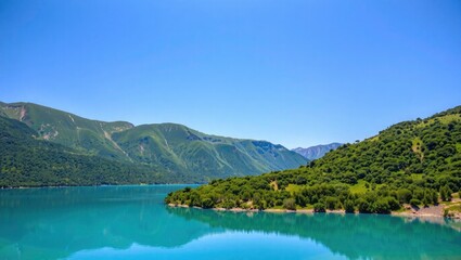 Fototapeta premium Serene Turquoise Lake, Lush Green Hills, Clear Sky Reflection