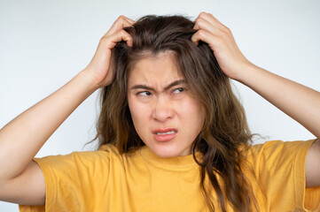 Fototapeta premium Asian woman scratching her scalp caused of itchy scalp. Dandruff and an inflammatory skin condition called seborrheic dermatitis are the most common causes of itchy scalp.