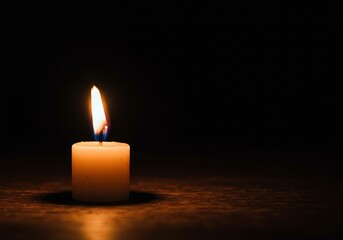 A solitary candle illuminates the darkness with its soft, flickering flame, creating a calming and serene atmosphere full of warmth and tranquility