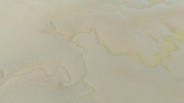 A beautiful aerial drone view of the exposed tidal mudflats during low tide on the west coast of South Korea &mdash; showcasing the serene and expansive coastal landscape of nature