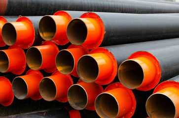 New pipes at a construction site. Stacks of black pvc plastic pipe outdoors. Plastic water pipes. Industrial PE pipeline for gas and water. HDPE pipe, Polyethylene PE100 pipe.
