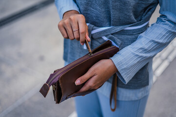 Brown leather wallet in the hands of fashionable women