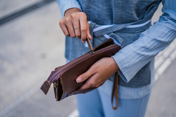 Brown leather wallet in the hands of fashionable women