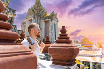 Caucasian male tourist exploring wat arun at sunset in Bangkok, Thailand