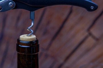 Wine bottle being opened by a waiter using a corkscrew, ready to be served to customers
