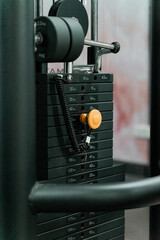 sstkWellness captures the essence of modern fitness with this striking image of a mechanical strength training machine loaded with weight plates, highlighting the synergy between structured physical