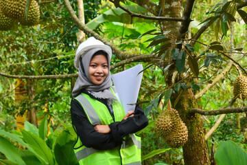 Young Asian woman farmer checking industrial scale durian plantation © Ayudia