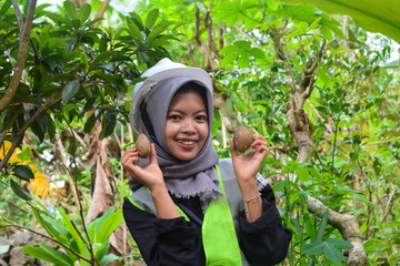 Young Asian woman farmer checking industrial scale durian plantation © Ayudia