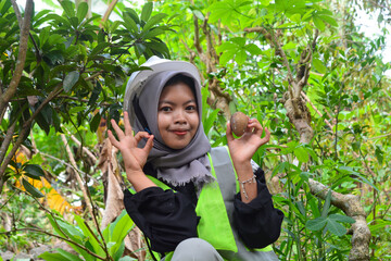 Young Asian woman farmer checking industrial scale durian plantation © Ayudia