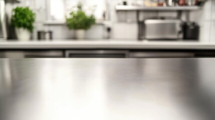 Empty stainless tabletop with blurred kitchen view background.