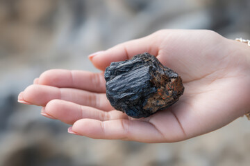 Close-up of a female hand holding Himalayan Shilajit resin for natural health and wellness benefits