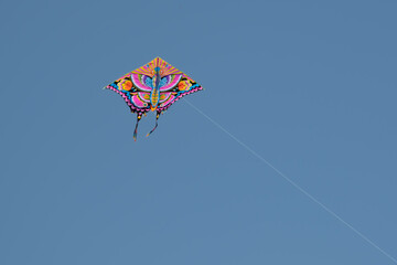 Colorful Butterfly-Shaped Kite Flying in Clear Blue Sky