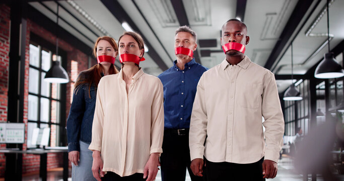 Business Team Silenced With Black Duct Tape In Office Meeting. The Man