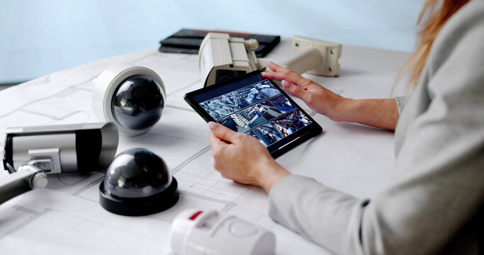 Woman Monitoring CCTV Security And Fire Surveillance Footage On Tablet - Powered by Adobe
