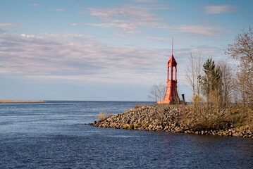 an old red iron lighthouse on the river bank