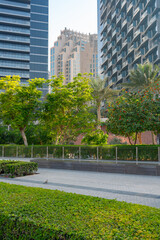 Urban park with lush greenery surrounded by modern high-rise buildings in Dubai, UAE