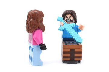Fototapeta premium Lego minifigures of Garrett and Steve main character from video game Minecraft and movie are doing with weapons or swords. Editorial illustrative image of popular plastic toys.