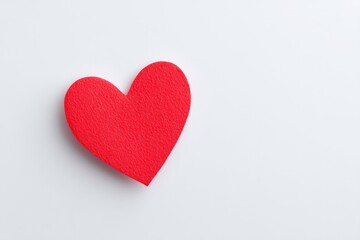 Fototapeta premium minimalist image showcasing single red heart on plain white background