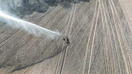 Aerial drone view of irrigation system, water jet rain guns sprinklers on field, rural scene landscape on sunny day, field background, agriculture in the Netherlands