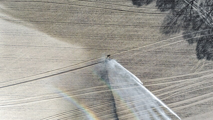 Aerial drone view of irrigation system, water jet rain guns sprinklers on field, rural scene landscape on sunny day, field background, agriculture in the Netherlands