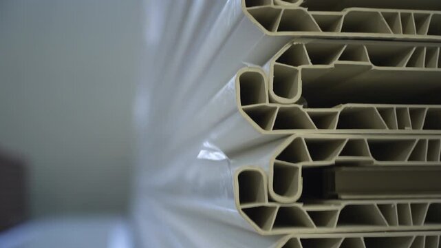 Modern plastic windowsills stack with geometric texture inside in warehouse closeup. Made with extrusion PVC furniture details in storag with copy space