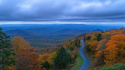 Autumnal mountain road winding through colorful foliage, breathtaking vista