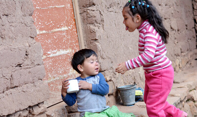 A little boy not willing to share the cup with his sister.