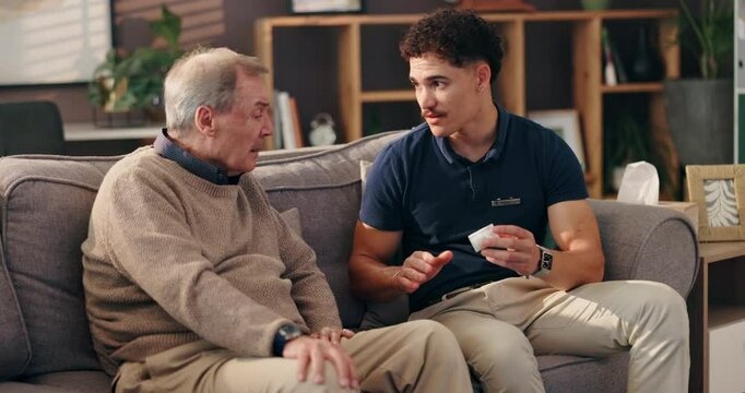 Medication, healthcare and caregiver with senior man in nursing home for medical consultation. Medicine, discussion and male person with elderly patient for explaining treatment plan in house.