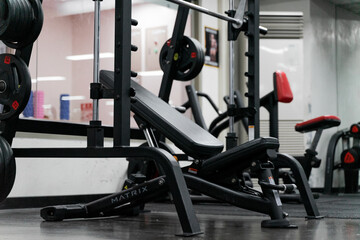 Fototapeta premium sstkWellness captures the essence of modern fitness with this striking image of a mechanical strength training machine loaded with weight plates, highlighting the synergy between structured physical
