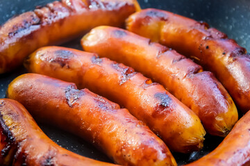 closeup of grilled sausages in a frying pan
