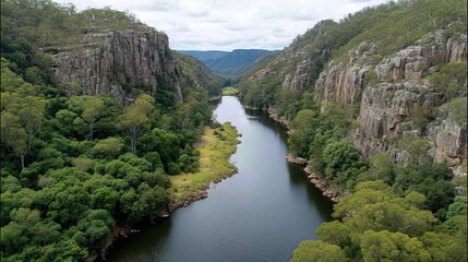 The majestic flow of the river cuts through rocky cliffs, surrounded by lush vegetation.