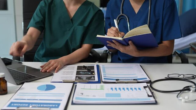Medical team working with a tablet and Laptop computer search for medical information at the hospital office.