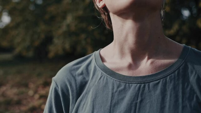 Calm outdoor moment: person breathing deeply in sunlit forest with gentle movement