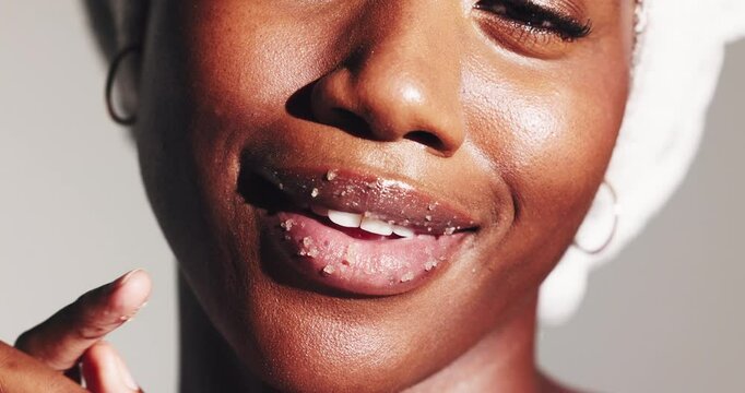 Woman, skincare and sugar scrub on lips for beauty treatment, shine or natural exfoliation. Closeup, mouth or happy model apply cosmetics on face for glow, peeling or clean on white studio background