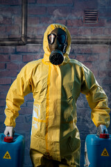 Man with gas mask and personal safety equipment transporting toxic material over a background of bricks. Vertical format.