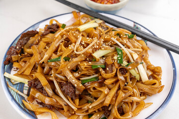 Stir fried rice noodle with beef served on a plate