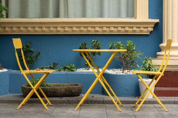 Vibrant yellow color chairs and table at the street