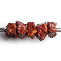 Grilled meat pieces skewered on a metal rod 