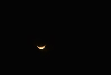 yellow half moon covering by cloud floating on sky in night background