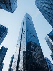 Bottom up view of reflective skyscraper buildings. Business office center in the big city, high rise building covered in glass window.