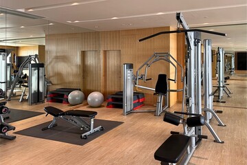 Fitness center with gym equipment and mirrored wall