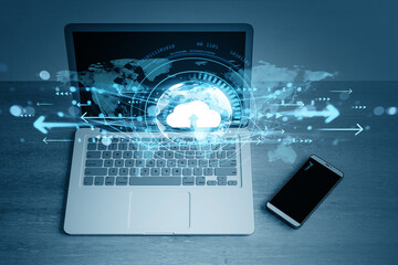 Naklejka na ściany i meble Cloud computing data transfer concept with digital interface over laptop and smartphone on wooden desk in business technology background.