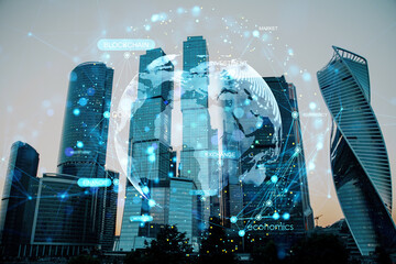 Futuristic holographic globe overlay and digital finance network data on skyscrapers in city business district background at dusk.