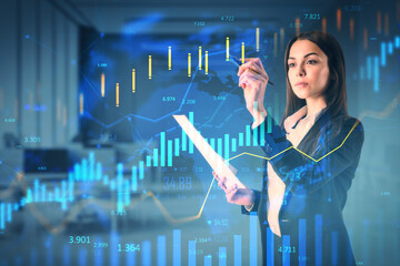 Businesswoman analyzing digital financial graphs with futuristic holographic overlay in modern office background, concept of market growth and investment.