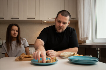 Young adults cooking together in modern home kitchen, focus on food preparation.