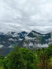 Fototapeta premium Misty Joshimath Mountain View: Scenic Himalayan Landscape with Fog and Greenery
