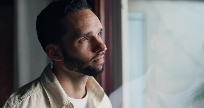 Sad, thinking and window with man at home for mental health, memory and psychology. Mistake, fear and loneliness with male person in living room of house for depression, grief and reflection